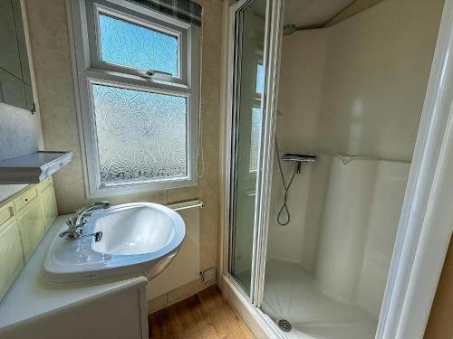 a bathroom with a sink and a shower and a window at Superb Caravan With Decking At Kessingland Beach In Norfolk Ref 90038Td in Benacre