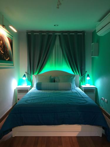a bedroom with a bed with green lighting at White Turquoise -1 Bedroom Apartment- in Bangkok