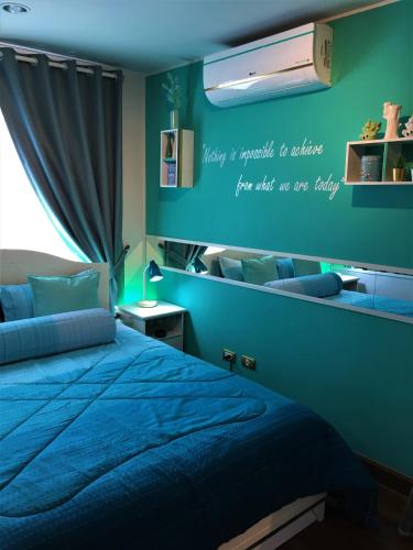 a bedroom with a bed and a blue wall at White Turquoise -1 Bedroom Apartment- in Bangkok