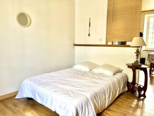 - une chambre avec un lit blanc, une table et une fenêtre dans l'établissement Spacieux studio 48 m², cœur de ville, Étretat - FR-1-479-221, à Étel