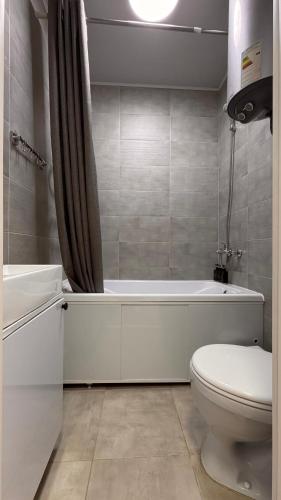 a bathroom with a toilet and a tub and a sink at Квартира 6-35 in Aktau