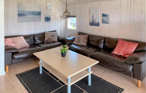 a living room with a leather couch and a coffee table at Holiday Home Strandparken Xi in Otterup
