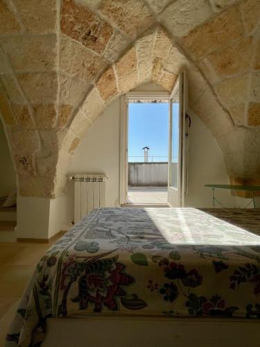 a bed in a room with a large window at Dimora Orsini del Balzo in Carovigno