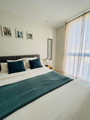 a large bed in a room with a large window at Modern apartment with balcony and free parking in Porto