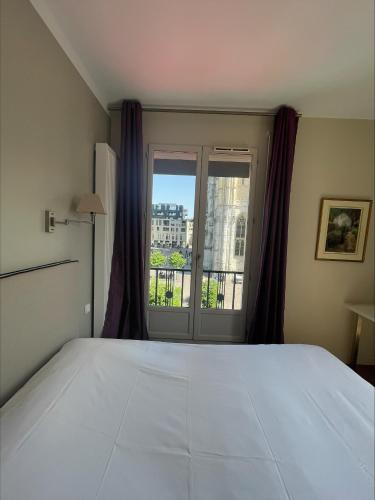 Postel nebo postele na pokoji v ubytování Hôtel Cardinal