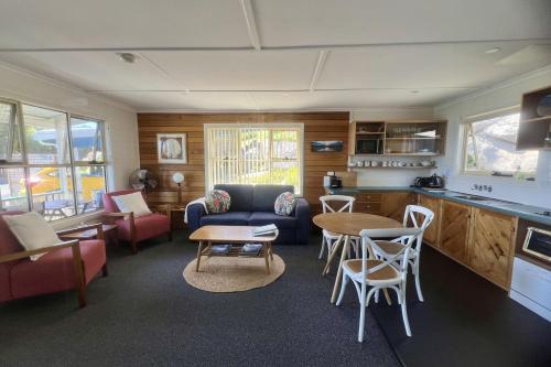 a kitchen and a living room with a table and chairs at BINALONG BEACH COTTAGE Beachfront at Bay of Fires Next to Restaurant in Binalong Bay
