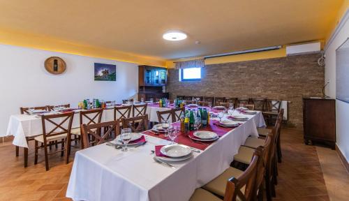 a dining room with white tables and chairs at Borhotel Sziluett Farkasmály in Gyöngyös