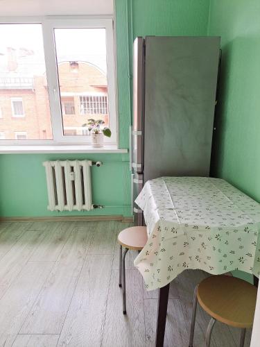 a bed in a room with a table and a window at Baznicas Str Apartments in Liepāja