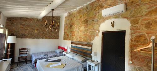 a bedroom with two beds and a brick wall at Well in Filettole