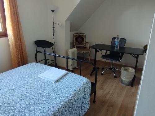 a bedroom with a bed and a desk and a table at Chambre 2 en Pavillon BONNEUIL SUR MARNE in Bonneuil-sur-Marne