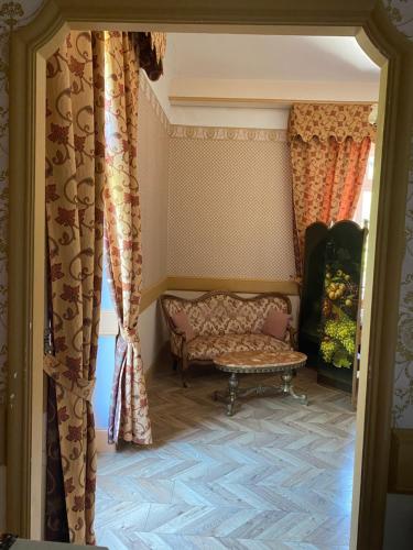 a living room with a couch and curtains at Suite romantique d'Isoarde des Baux - Château de Rochetaillée in Saint-Uze