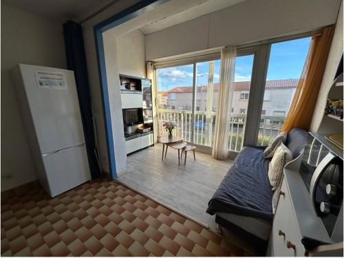 Elle comprend un salon avec un réfrigérateur et un balcon. dans l'établissement Noug, à Valras-Plage
