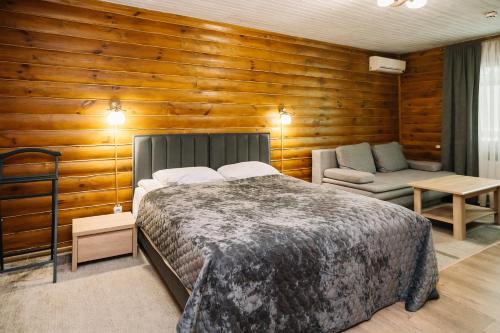 a bedroom with a bed and a couch in it at Рестпарк рекреаційний комплекс in Luts'k