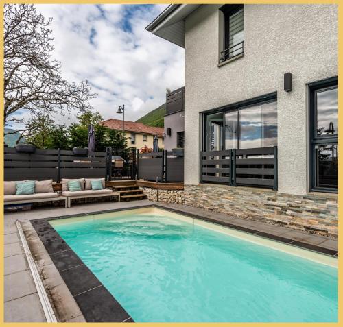 une piscine devant une maison dans l'établissement Détente, confort et sérénité, aux portes de Genève, à Collonges