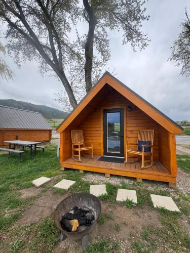 a log cabin with two chairs and a fire at Lost Trail in Lava Hot Springs