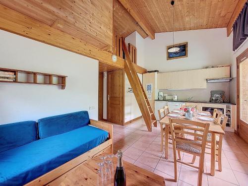un salon avec un canapé bleu et une table dans l'établissement APPARTEMENT PROCHE REMONTEES MECANIQUES - WIFI - MORZINE - 7 PERSONNES - JOUX 7, à Morzine