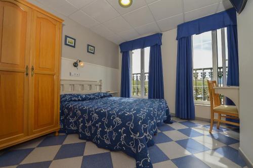 
a bedroom with a bed and a dresser at Hostal Linares in Ribadeo
