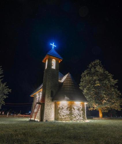 a church with a cross on top of it at night at Bujtina Pllumi Theth in Theth