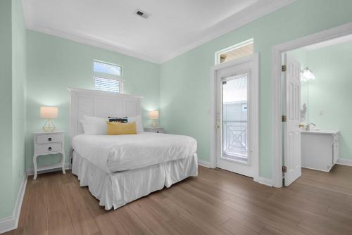 a white bedroom with a bed and a window at Brzee Bungalow in Destin