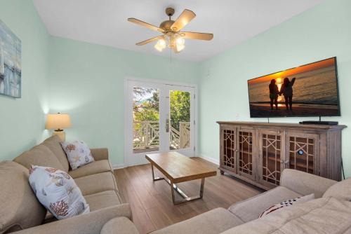 a living room with a couch and a flat screen tv at Brzee Bungalow in Destin