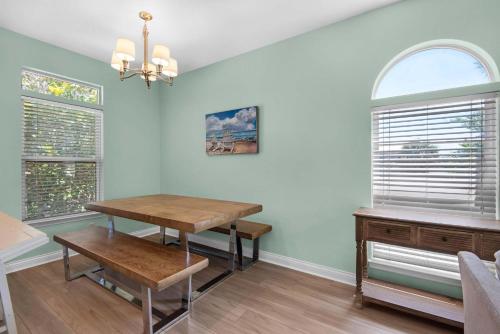 a dining room with a table and two windows at Brzee Bungalow in Destin