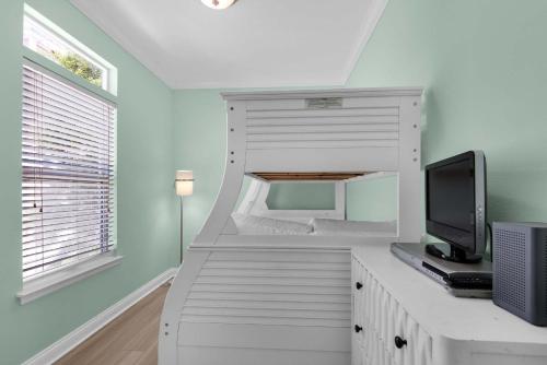 a room with a tv and a desk with a monitor at Brzee Bungalow in Destin