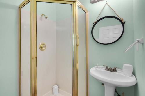 a bathroom with a shower and a sink and a mirror at Brzee Bungalow in Destin