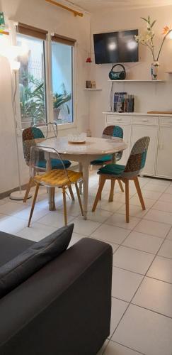 une cuisine avec une table et des chaises dans une pièce dans l'établissement Joli petit appartement centre de Mèze et plage, à Mèze
