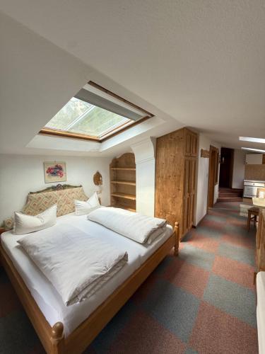 a bedroom with a large bed with a skylight at Häusl am Roan Reutte Höfen in Hofen