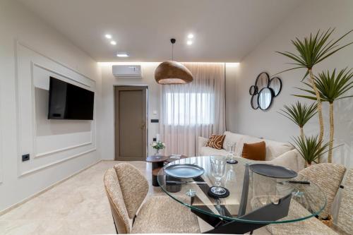 Una sala de estar con una mesa de cristal y sillas. en Ellan Luxury Living , By Idealstay Experience, en Heraclión