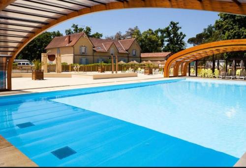 une grande piscine bleue avec une arche dans l'établissement bungalow le TXOKO, à Lit-et-Mixe