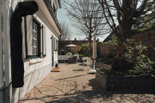 a brick walkway next to a house with a tree at Villa 'La Mer Veille - Bécassine' in Oostduinkerke - Bad in Oostduinkerke