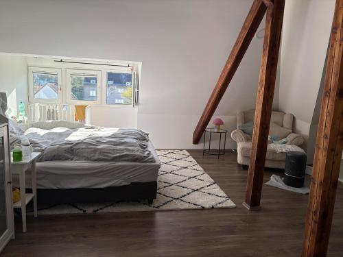 a bedroom with a bed and a staircase with a window at Wunderschöne Wohnung in Erftstadt-Liblar 15 Minuten bis zum Phantasialand! in Erftstadt