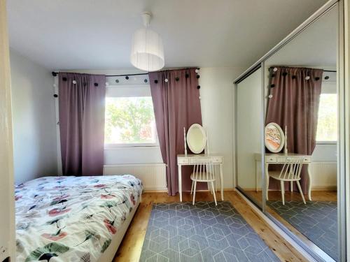 a bedroom with a bed and a large mirror at Cozy townhouse apartment in Kerava