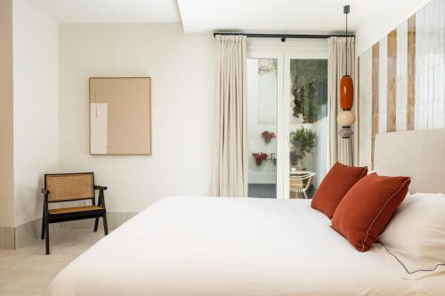 a bedroom with a white bed and a chair at Aristoy in Tarifa