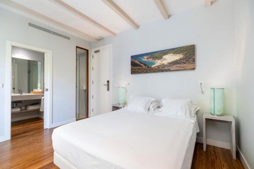 a white bedroom with a white bed and a bathroom at Aristoy in Tarifa