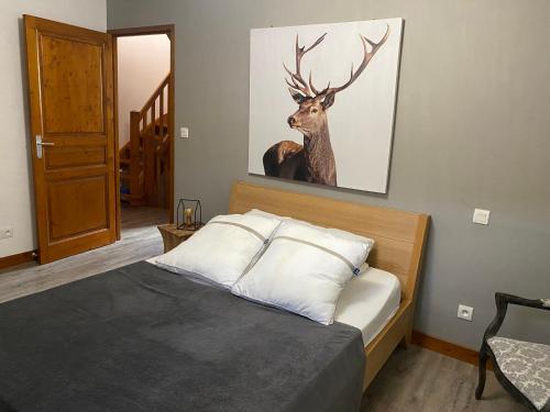 a bedroom with a bed with a deer painting on the wall at Le petit Repaire de Sailhan, Ecolodges in Sailhan