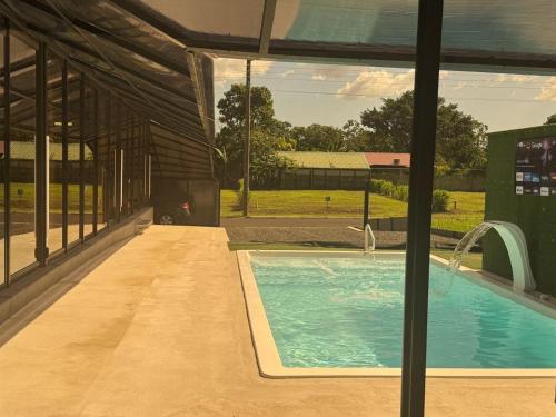 a swimming pool in a building with a large window at Casa Cristal # 1 in Fortuna