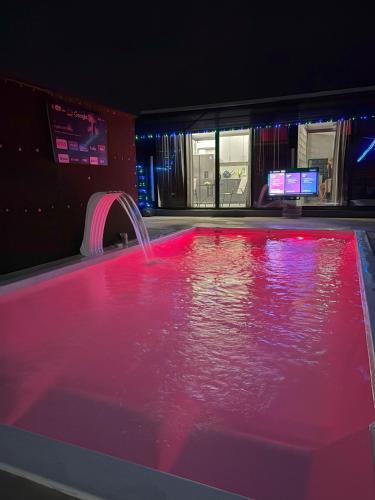 a hot tub with pink water and a fountain at Casa Cristal # 1 in Fortuna