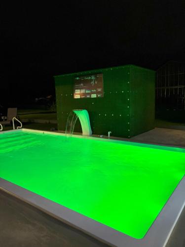 a swimming pool with a green glow in the dark at Casa Cristal # 1 in Fortuna