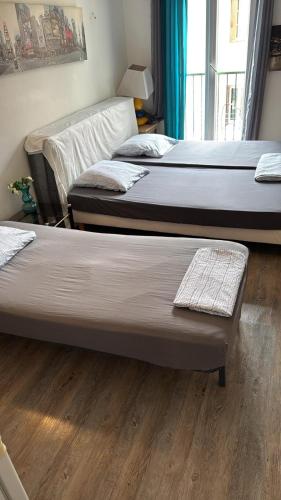 - 3 lits dans une chambre dotée de parquet dans l'établissement Ajaccio CATHEDRALE, à Ajaccio