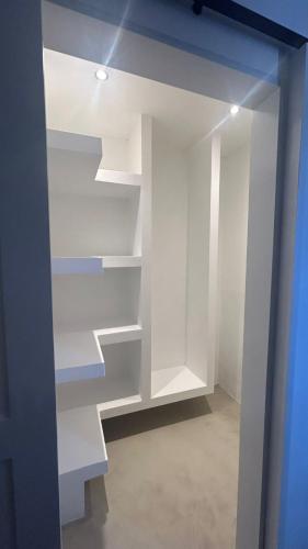 an empty closet with white shelves in a room at Gui Appartement in Midlands Station