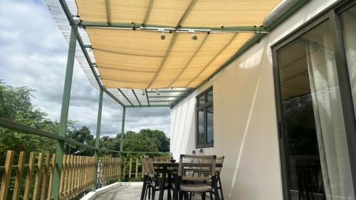a patio with a wooden canopy over a table and chairs at Gui Appartement in Midlands Station
