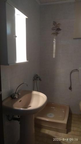 a bathroom with a sink and a toilet and a window at Alikes Apartment in Drosia