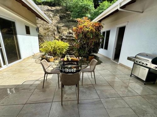 a patio with a table and chairs and a grill at Spectacular Luxury Rental With Ocean Views And Private Pool in Roatan
