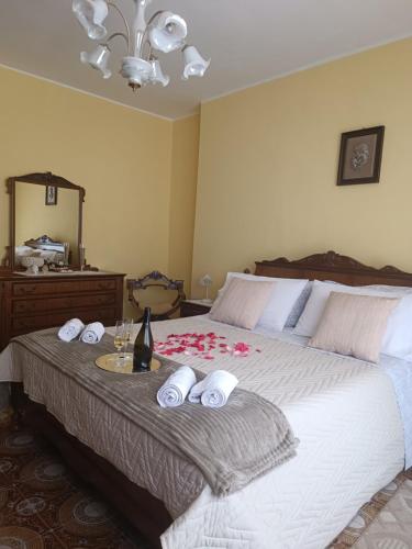 a bed with towels and a bottle of wine on it at Via San Vincenzo, 21 in Castiglione di Sicilia