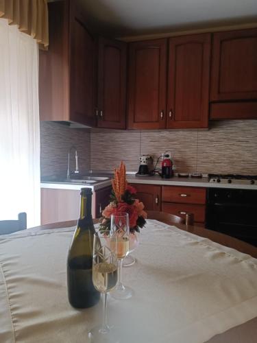 a bottle of wine and two glasses on a table at Via San Vincenzo, 21 in Castiglione di Sicilia