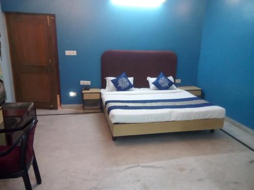a bedroom with a bed with blue walls at Hotel Mayur in Gwalior