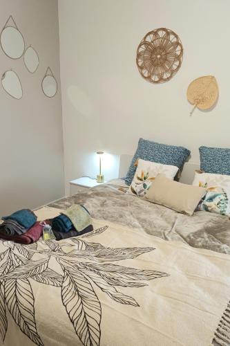 サン・マルタン・ダルデーシュにあるChambres d'hôtes & jacuzzi - A l'ombre des amandiersの葉っぱのデザインが施された大きなベッドのある寝室
