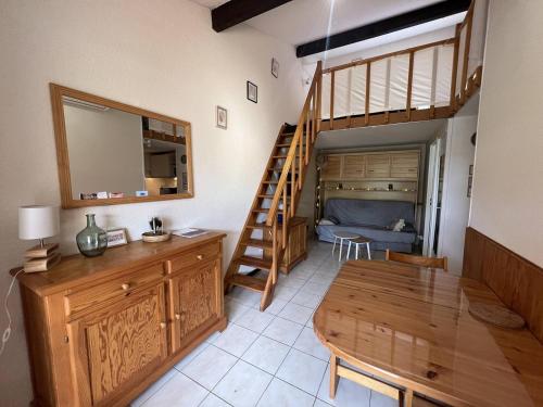 - un salon avec une table en bois et un escalier dans l'établissement Villa T2 mezzanine climatisée avec piscine, proche plage - La Franqui - FR-1-81-608, à La Franqui-Plage